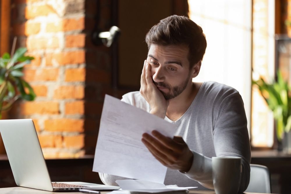 Man met brief met aanmaning gemeentelijke belastingen in de hand